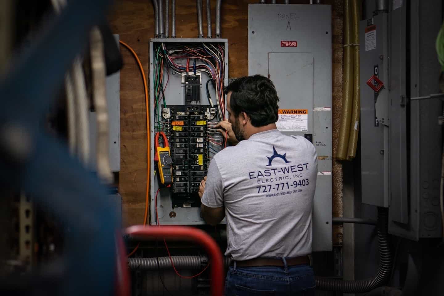East-West electrician servicing commercial electrical distribution equipment